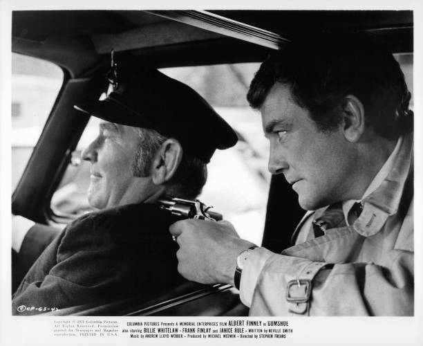 albert-finney-has-a-gun-to-the-driver-of-the-car-in-a-scene-from-the-picture-id130900879