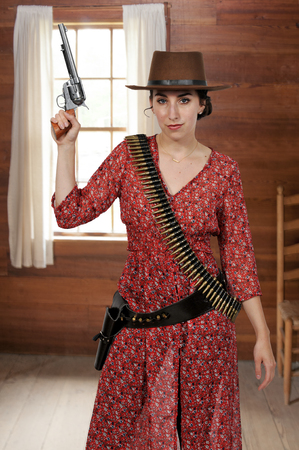 80994630-beautiful-young-country-girl-woman-wearing-a-stylish-cowboy-hat-and-revolver.jpg